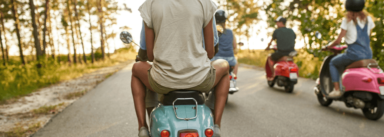 Groepje jonge mensen rijdend op scooters
